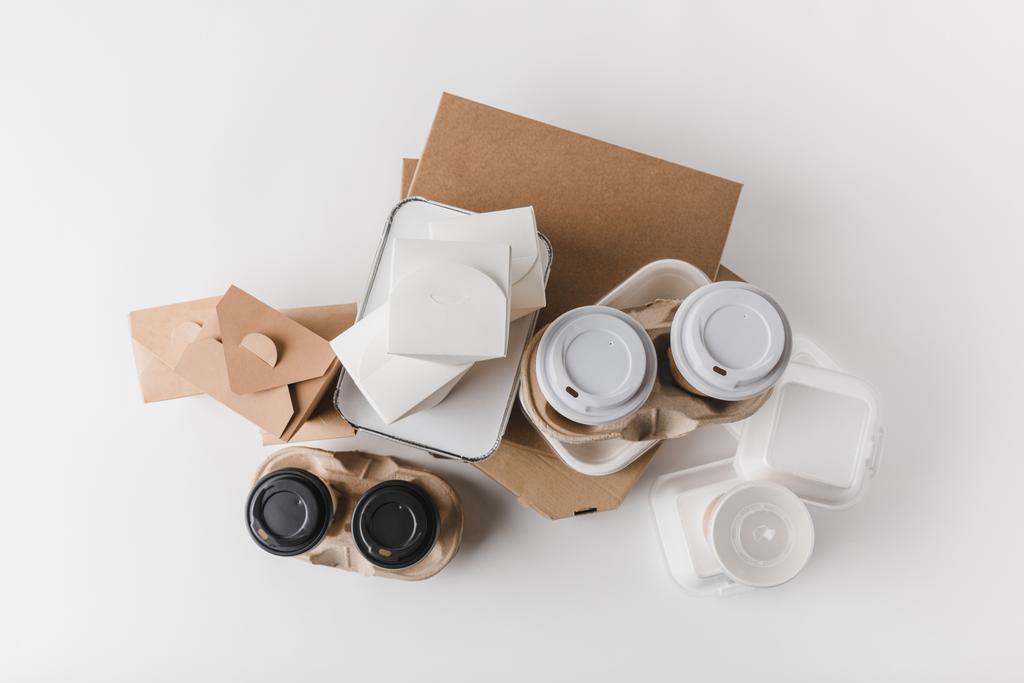 bovenaanzicht van pizzadozen en wegwerp koffie kopjes met noedels dozen op wit - Foto, afbeelding