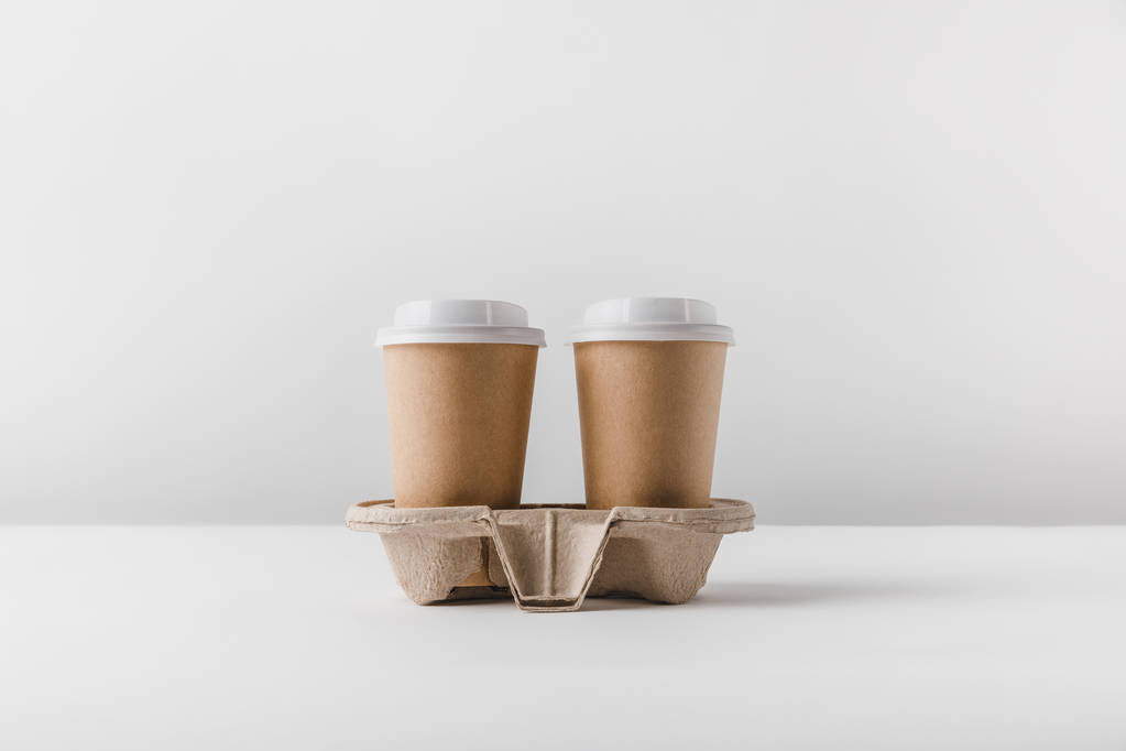two coffee in paper cups in cardboard tray on tabletop - Photo, Image