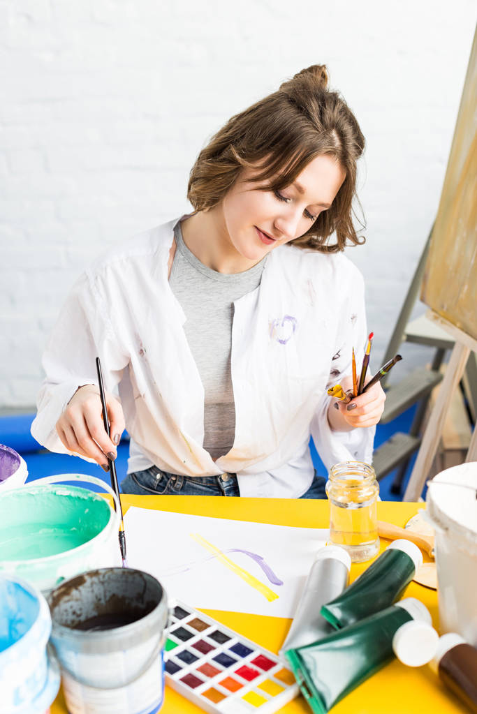 Young artistic girl making paint samples in light studio - Photo, Image
