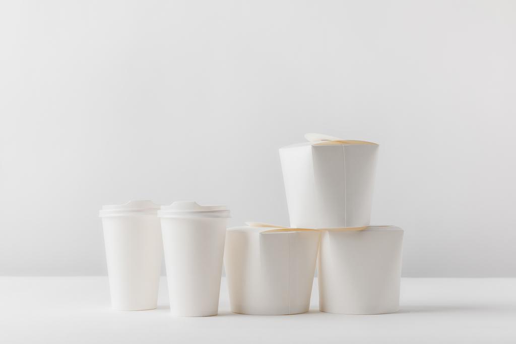 kutuları ve kahve kağıt bardak beyaz masada götürmek - Fotoğraf, Görsel