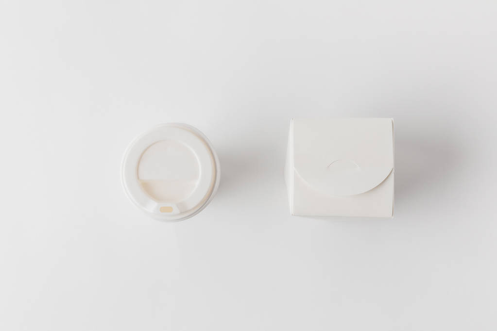 felülnézet, rendelkezésre álló kávé-kupa, és a tészta doboz, fehér felületre - Fotó, kép