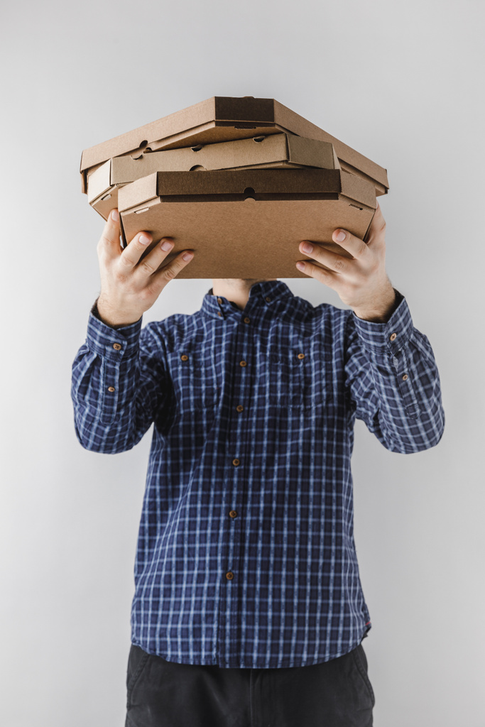 Kurier hält Pizzakartons isoliert auf weißem Grund - Foto, Bild
