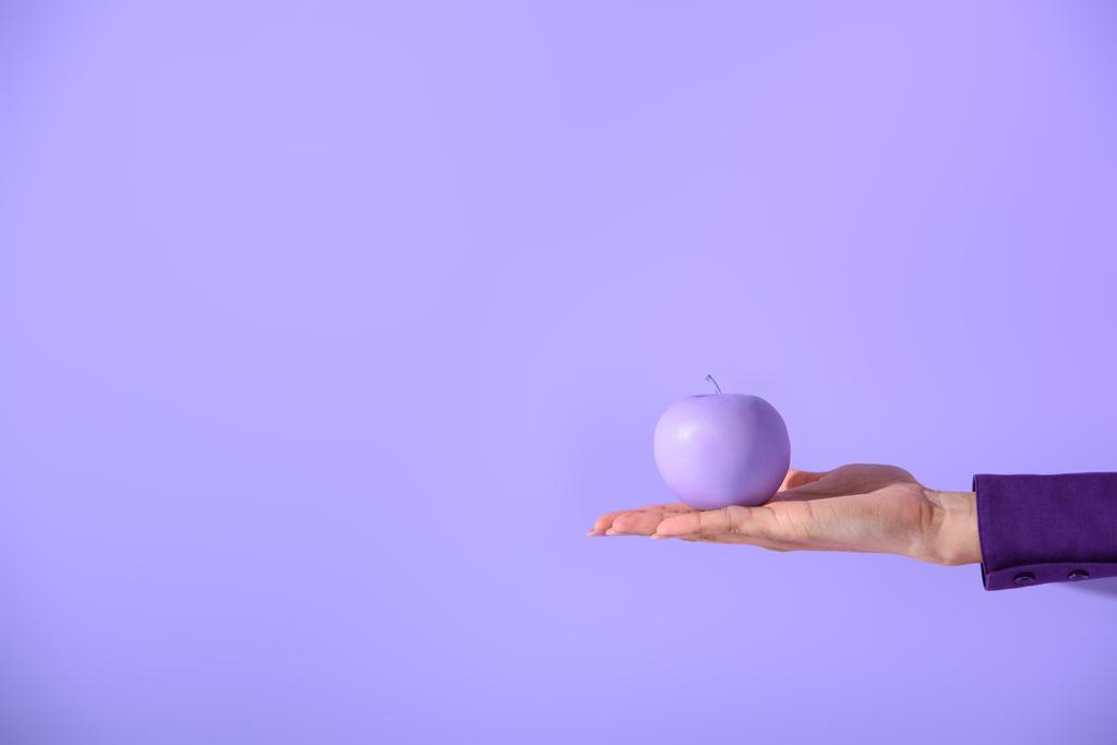 περικοπεί προβολή στο γυναικείο χέρι που κρατά το μωβ μήλο, απομονώνονται σε ultra violet - Φωτογραφία, εικόνα