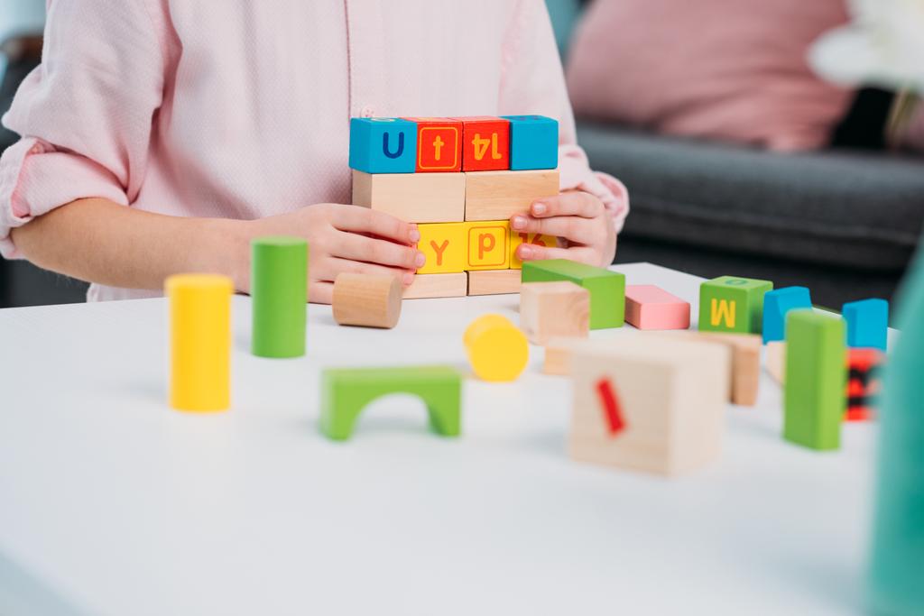 partial view of kid playing with colorful blocks at home - Fotoğraf, Görsel