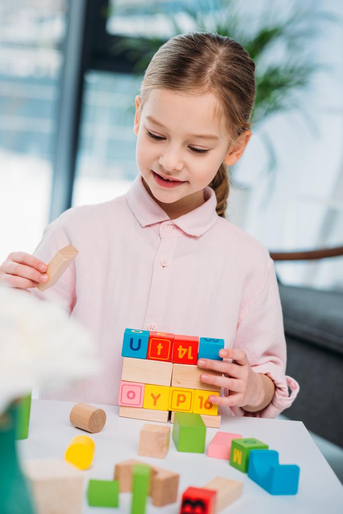 портрет милої дитини, що грає з барвистими блоками вдома
 - Фото, зображення