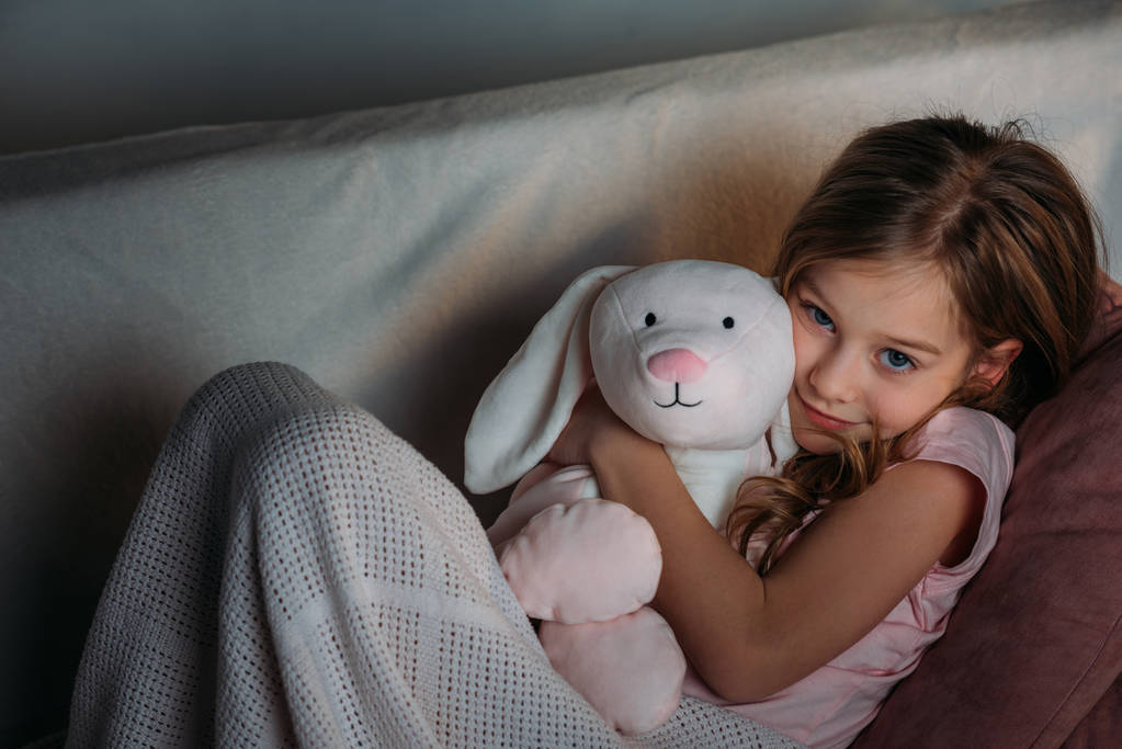 портрет милої дитини з іграшкою, що відпочиває на дивані
 - Фото, зображення
