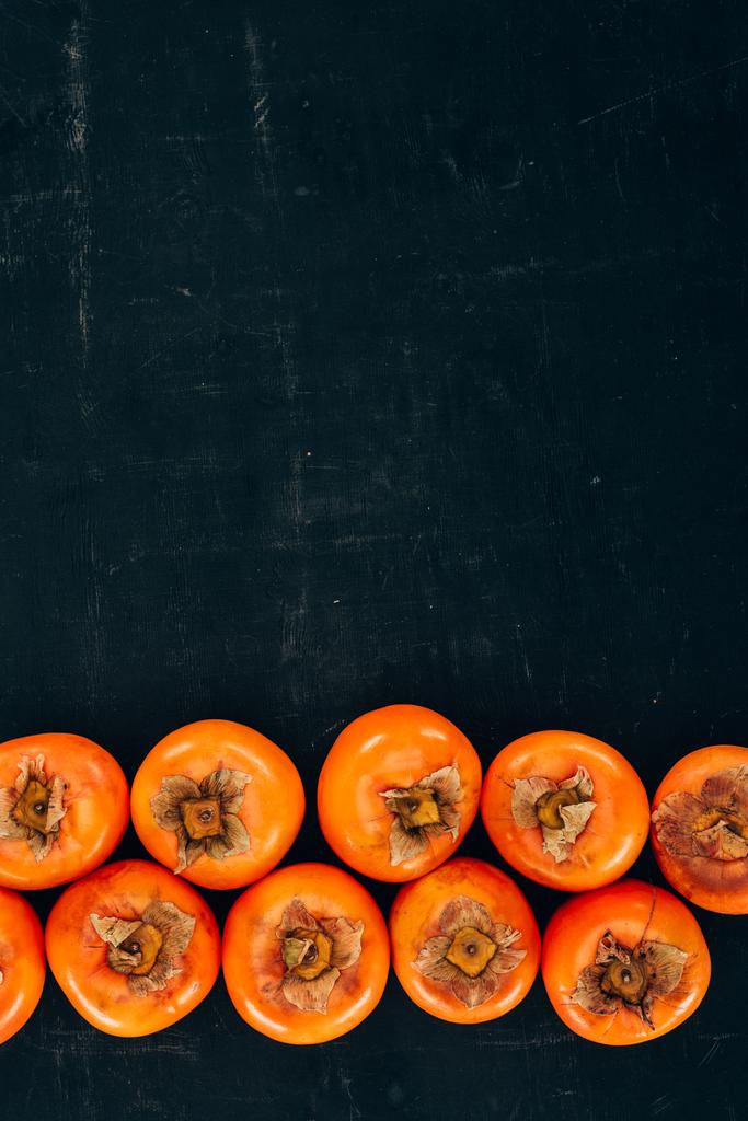 黒の熟したおいしい柿の行のトップ ビュー - 写真・画像