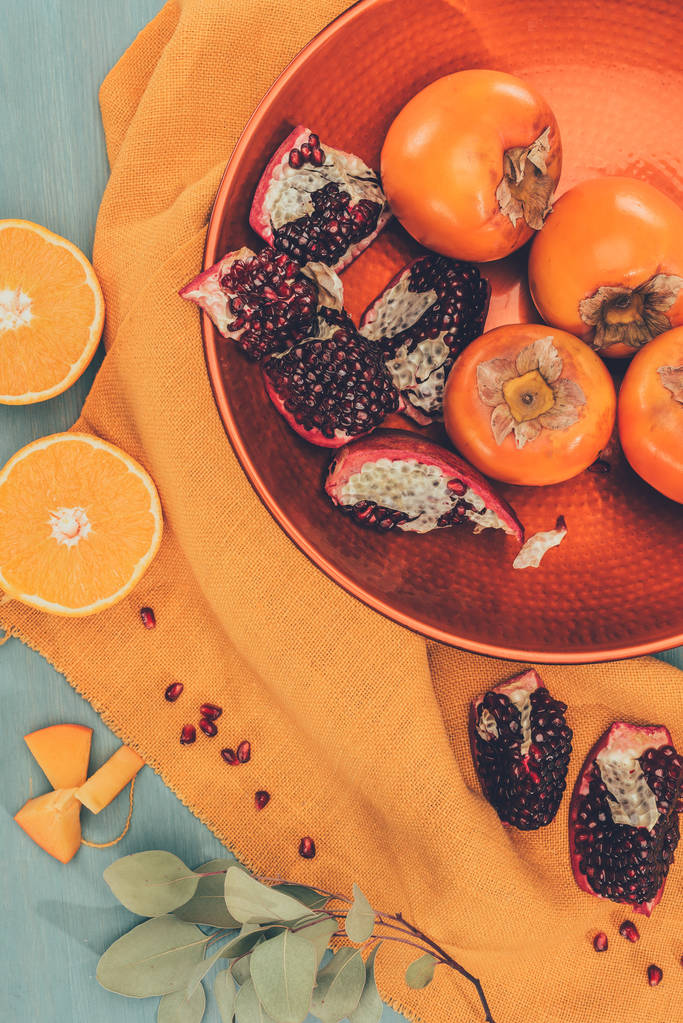 вид зверху смачні фрукти на тарілці на помаранчевій скатертині
 - Фото, зображення