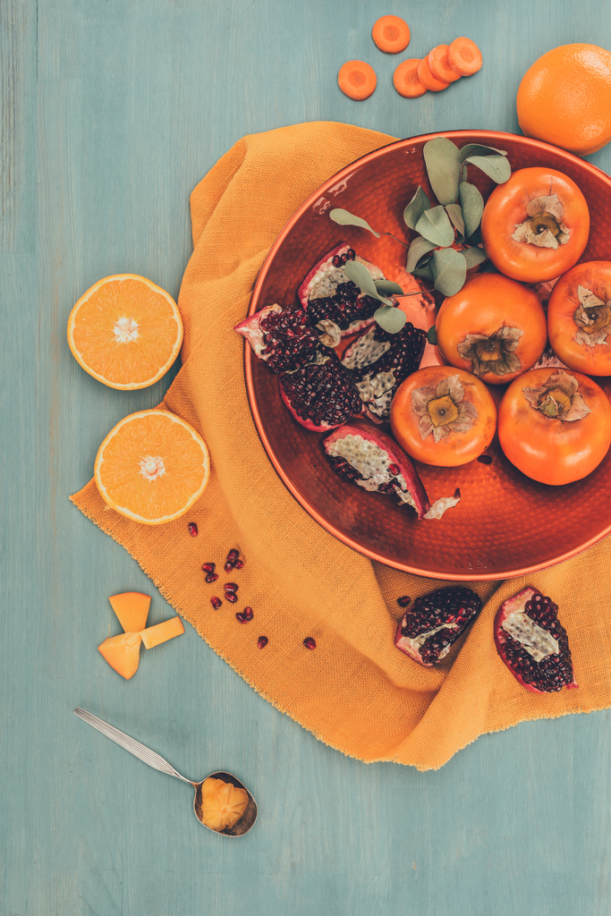 Olgunlaşmış meyve üstten görünüm plaka üzerinde turuncu masa örtüsü - Fotoğraf, Görsel