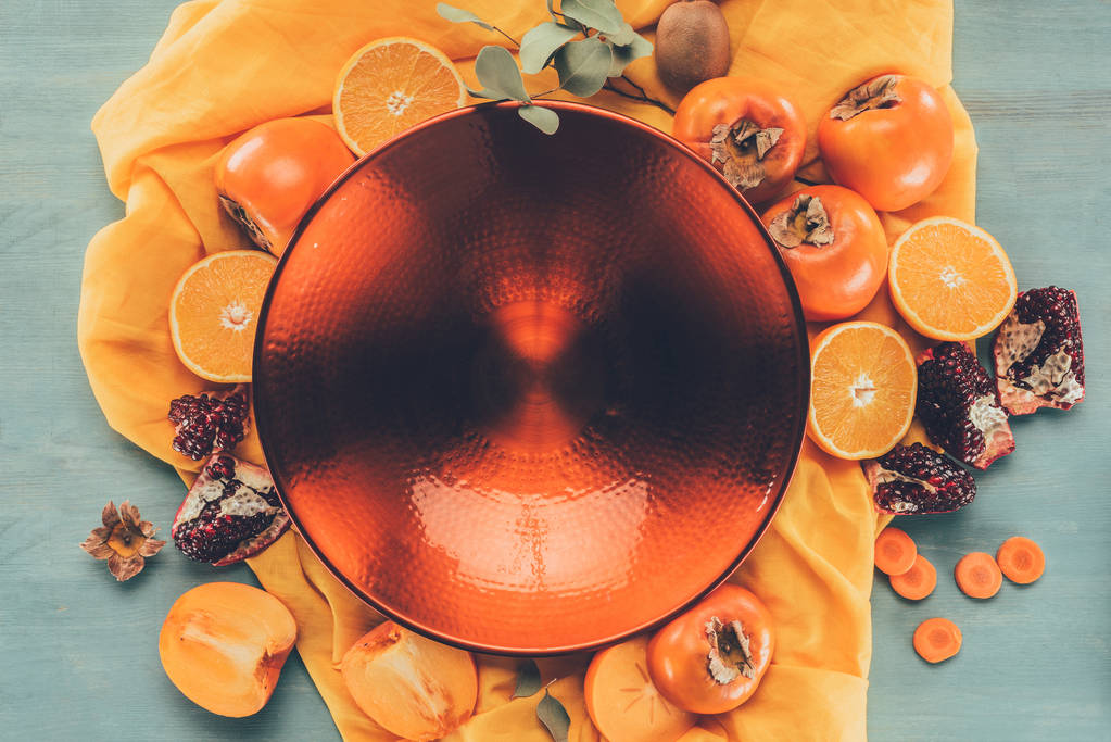 вид сверху на большую красную тарелку между фруктами
 - Фото, изображение