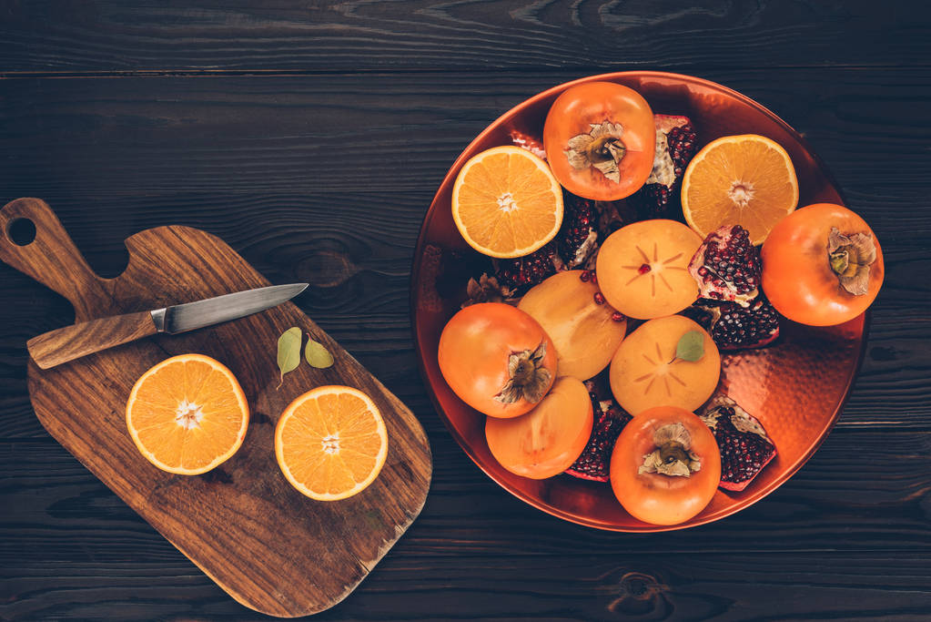 top view of fruits on plate and wooden board - Photo, Image