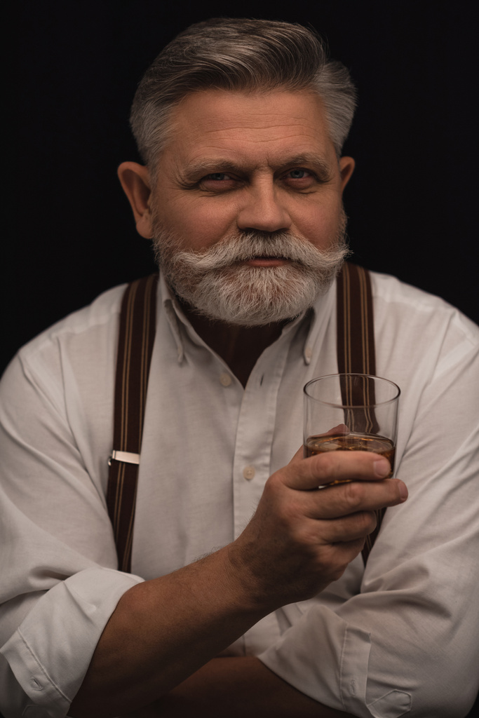 hombre mayor con estilo con vaso de whisky aislado en negro
 - Foto, Imagen