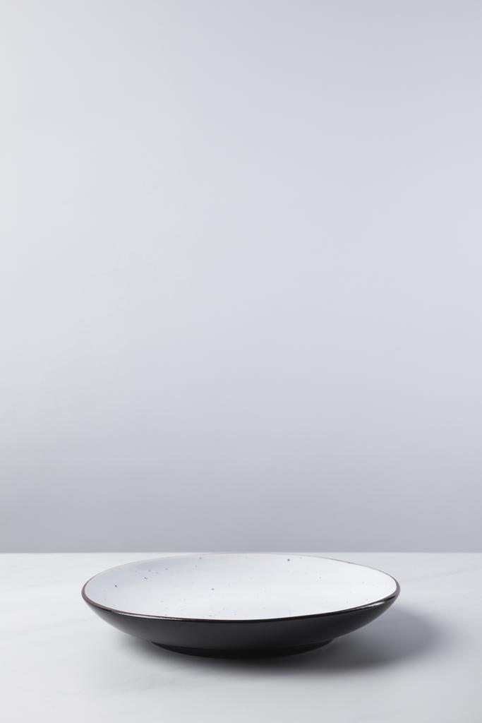 Plate placed on white surface, minimalistic conception - Photo, Image