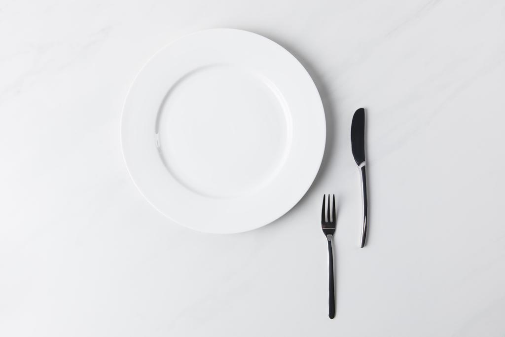 Vista superior da placa com garfo e faca, concepção de compromissos de mesa
 - Foto, Imagem