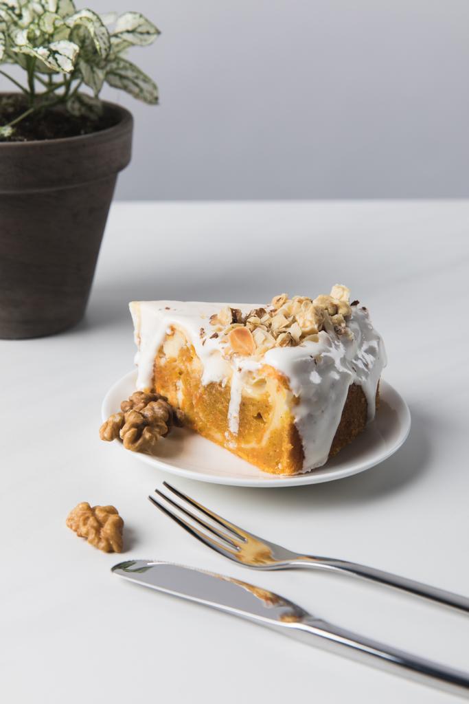 Торт на тарелке рядом с картофелем с вилкой и ножом
 - Фото, изображение