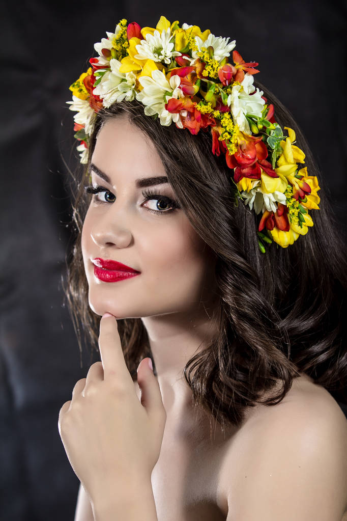 Fashion makeup. A woman with flowers on a black background - Photo, Image