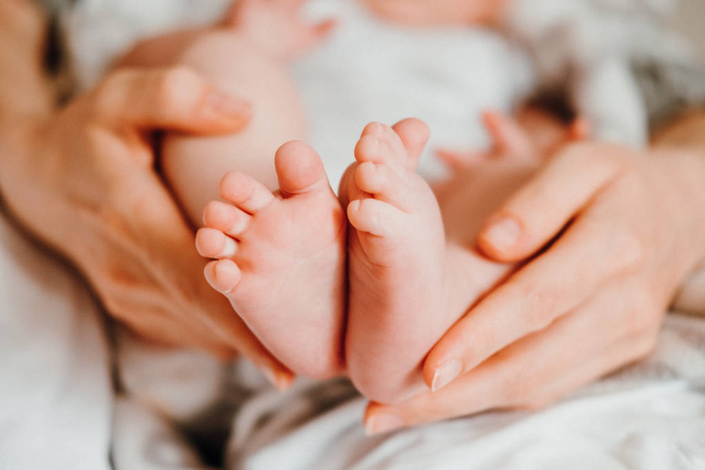 Mignon nouveau-né pieds dans les mains de la mère. Concept Happy Family
. - Photo, image