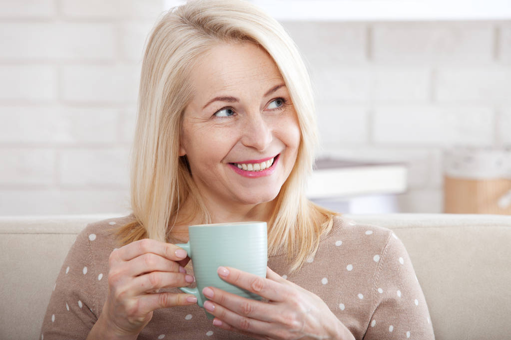 Portrait of happy blonde with mug in hands - Photo, Image