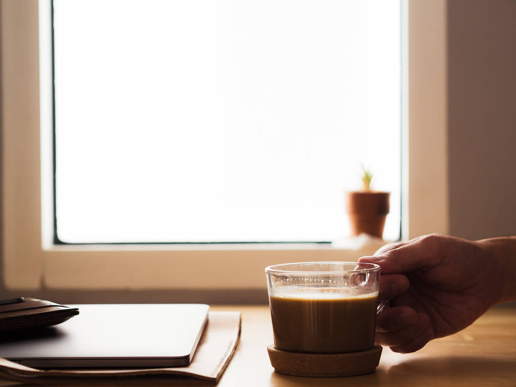 Beber café na mesa de trabalho com laptop pela janela ligh
 - Foto, Imagem