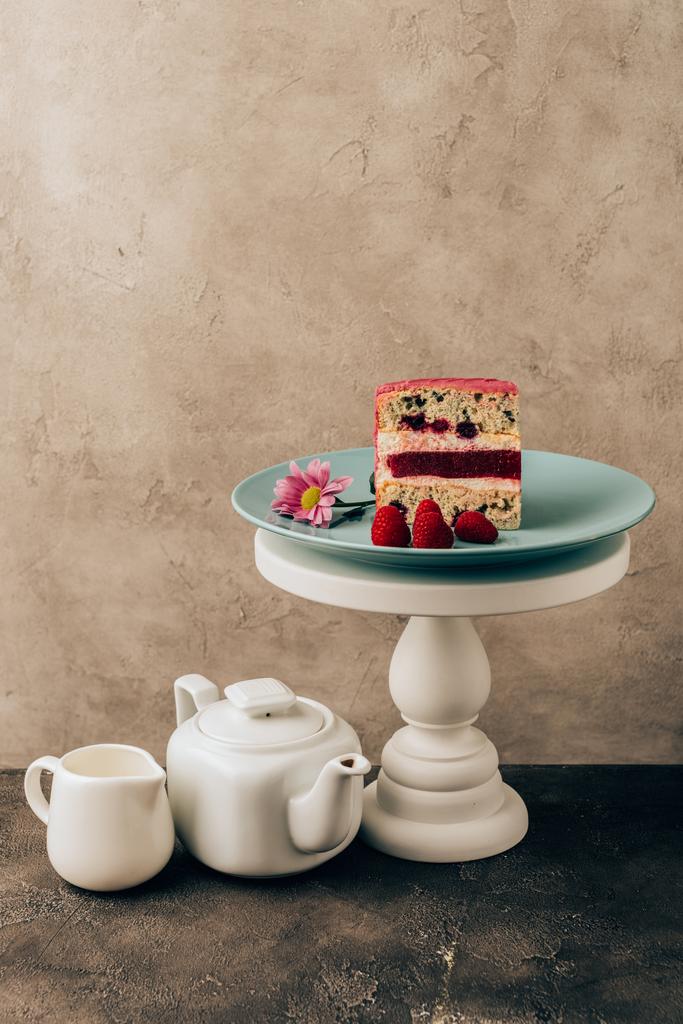 édes finom torta málna és a virág és a vízforraló porcelán kancsó - Fotó, kép