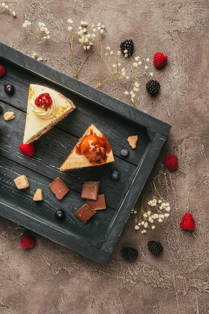 木製トレイのチョコレートとベリーの甘いおいしいケーキの上から見る - 写真・画像