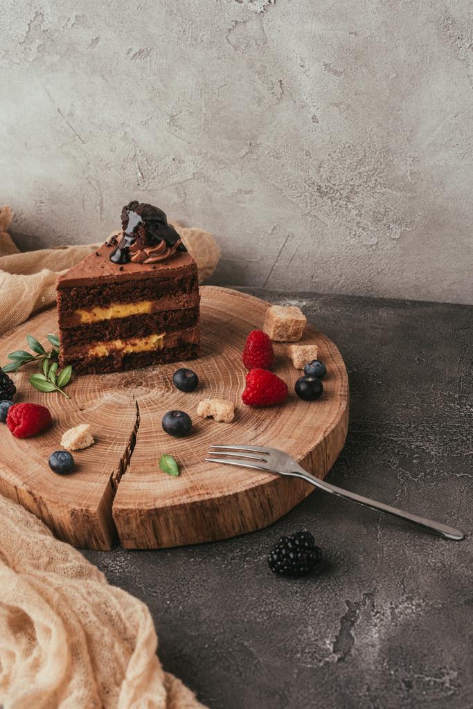 close-up view of delicious chocolate cake with berries on wooden board  - Photo, Image