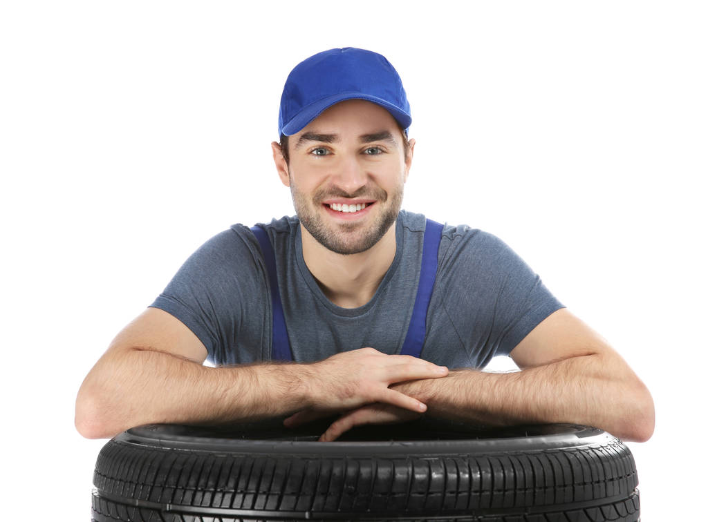 Nuori mekaanikko yhtenäinen auton rengas valkoisella taustalla
 - Valokuva, kuva