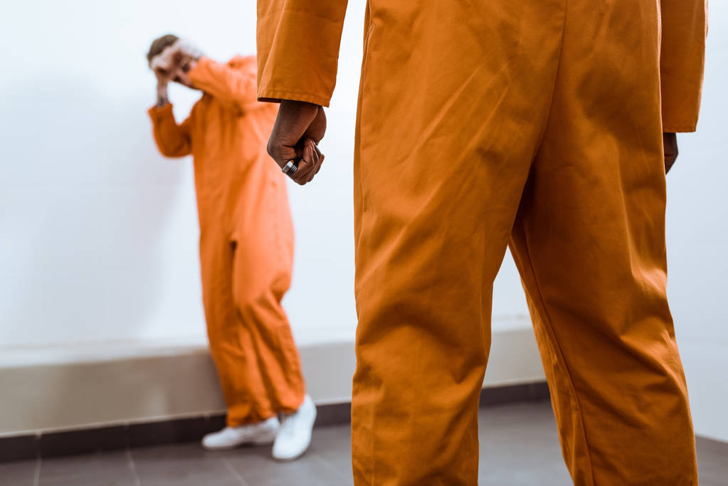περικομμένη εικόνα της πολυπολιτισμικής κρατούμενους που αγωνίζονται στο κελί της φυλακής - Φωτογραφία, εικόνα