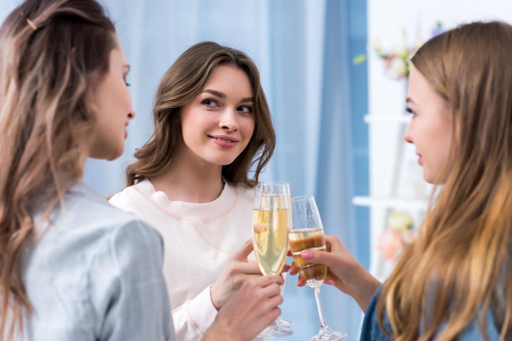 kauniit nuoret naiset juovat samppanjaa ja puhuvat
 - Valokuva, kuva