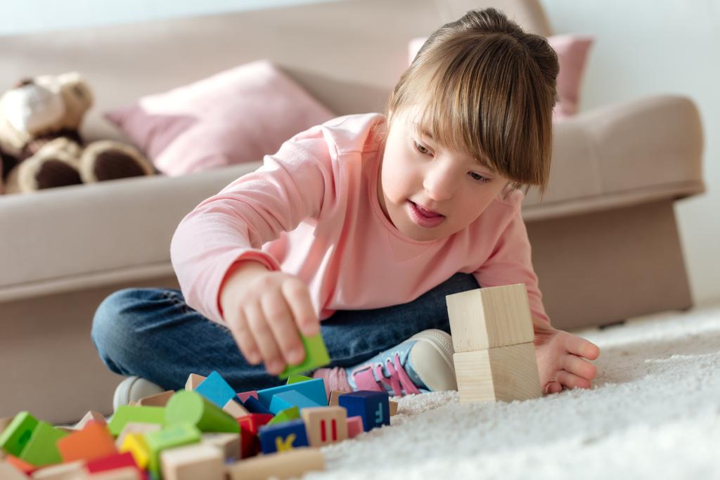 Enfant avec syndrome du duvet jouant avec des cubes de jouets
 - Photo, image