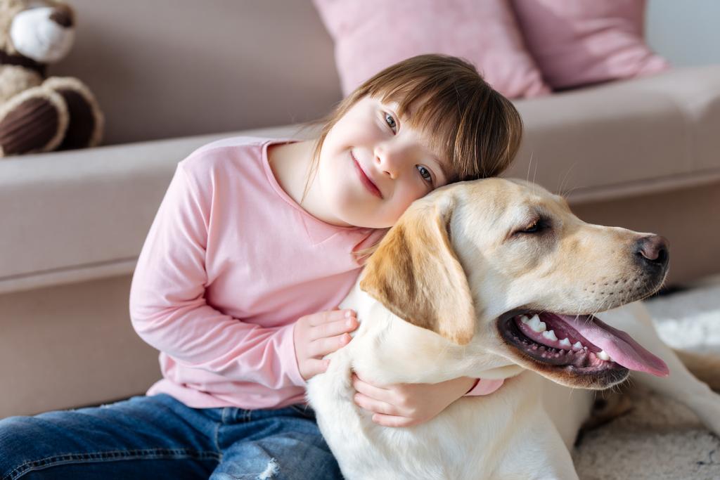 Lapsi alas oireyhtymä halailu koiran kanssa
 - Valokuva, kuva