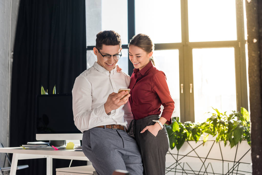 feliz empresários casal no escritório moderno usando smartphone juntos
 - Foto, Imagem