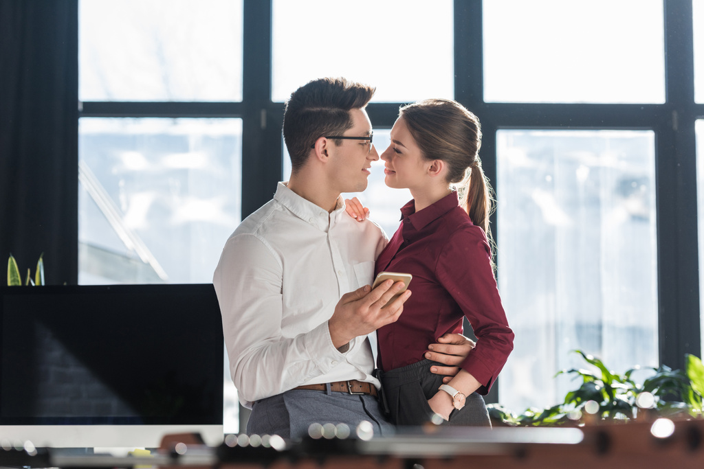 atraente beijos jovens empresários em roupas formais com escritório romance
 - Foto, Imagem