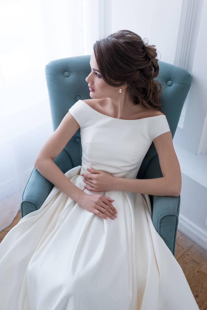 attrayant jeune mariée en robe de mariée assis dans le fauteuil
 - Photo, image