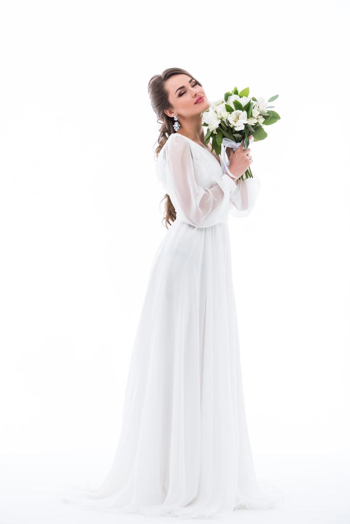 dreamy bride posing in dress with wedding bouquet, isolated on white - Photo, Image