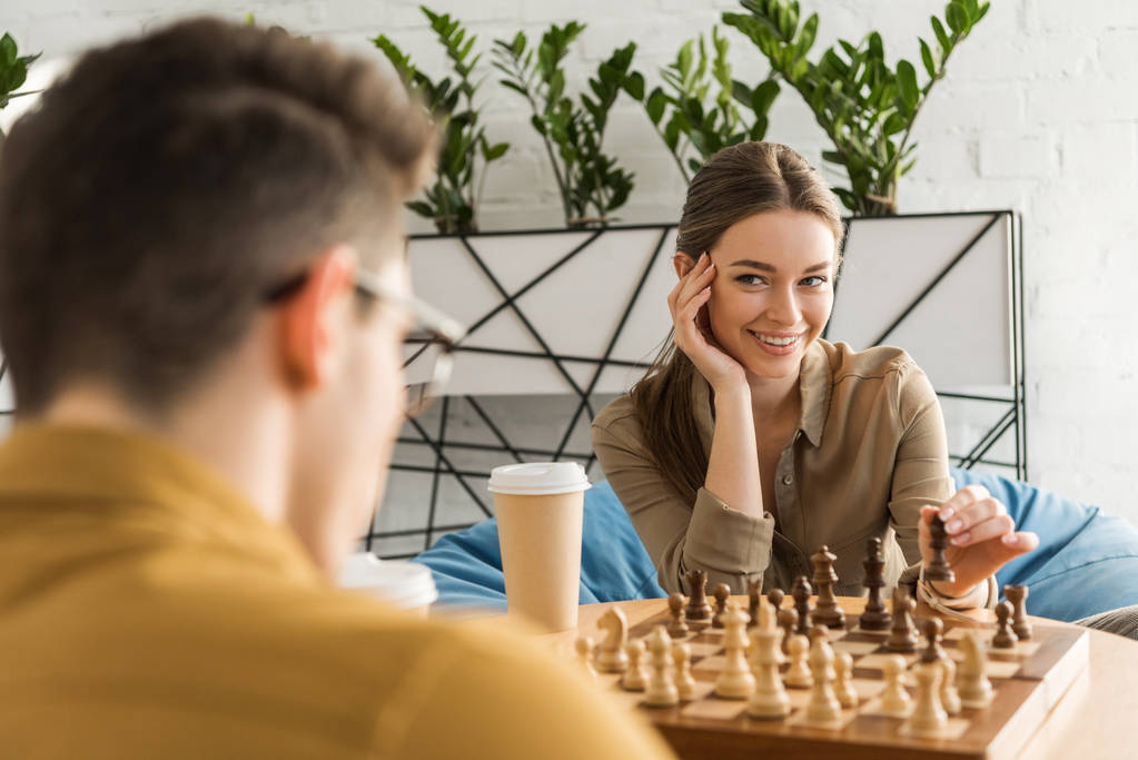 Młoda kobieta, gra w szachy i flirtuje z przeciwnikiem - Zdjęcie, obraz