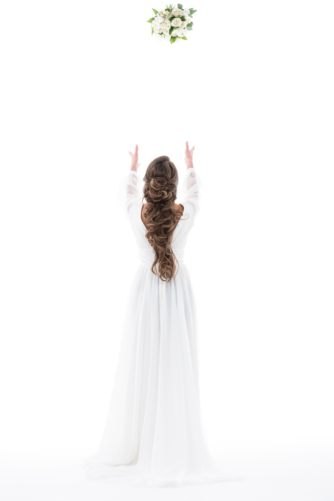Rückansicht der Braut im weißen Kleid beim Brautstrauß werfen, isoliert auf weiß - Foto, Bild