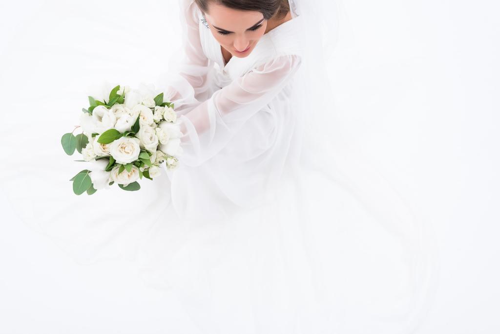 κάτοψη της νύφης με παραδοσιακή ενδυμασία κρατά γαμήλια ανθοδέσμη, απομονώνονται σε λευκό - Φωτογραφία, εικόνα