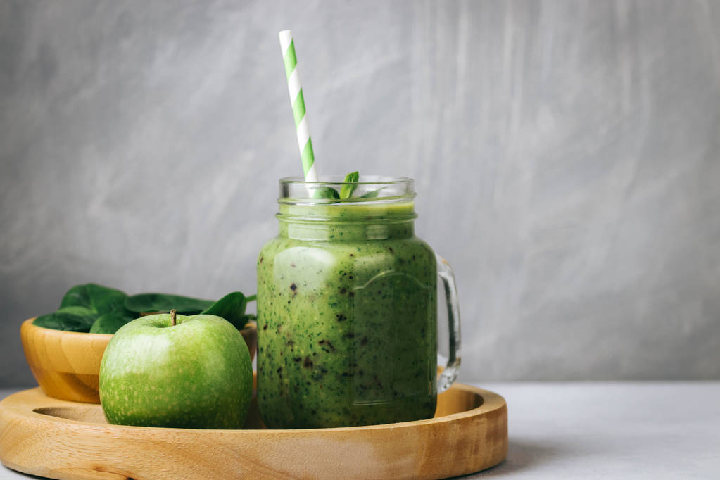 Zdrowe śniadanie, zielony smoothie w szklanym słoiczku, a niektóre składniki - szpinak i apple. Pożywienie, żywności detox - Zdjęcie, obraz