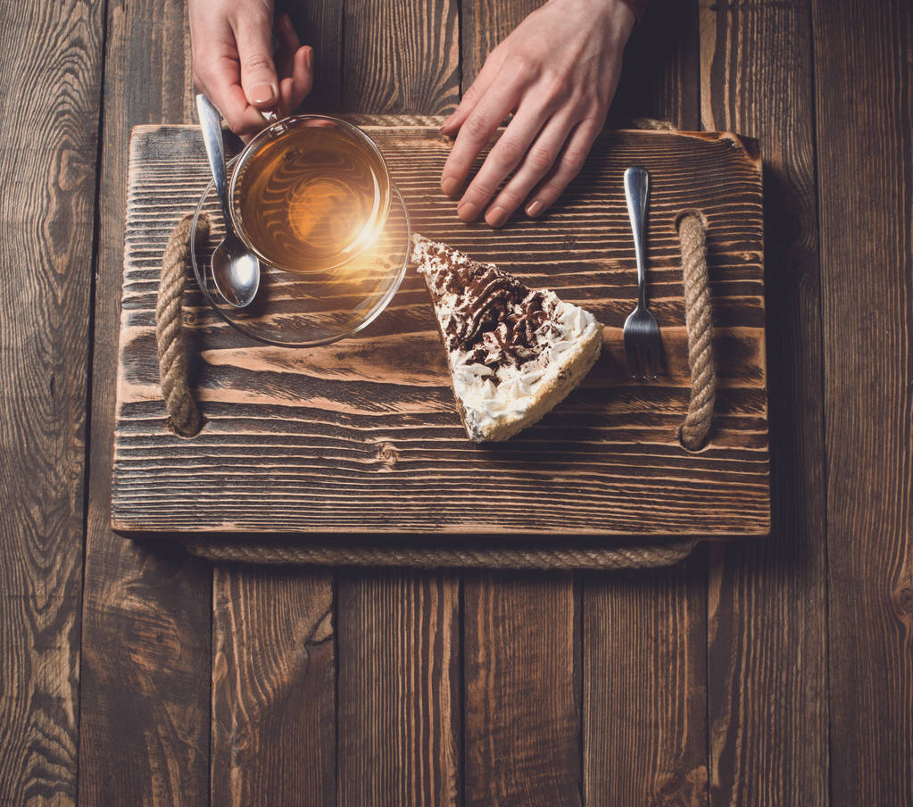 mãos com chá e bolo na mesa de madeira
 - Foto, Imagem