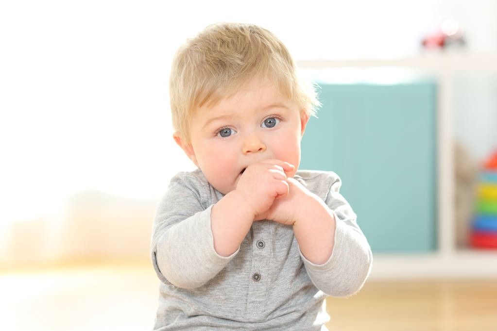 Портрет ребенка, кусающего пальцы, смотрящего на тебя
 - Фото, изображение