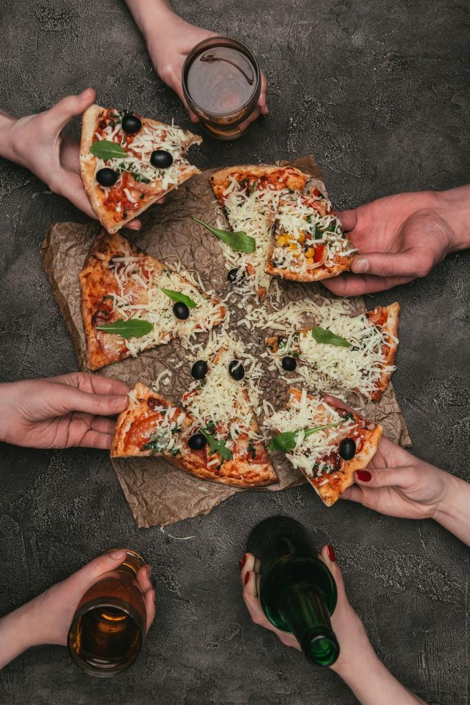 Vue rapprochée d'amis mangeant de la pizza sur fond sombre
 - Photo, image