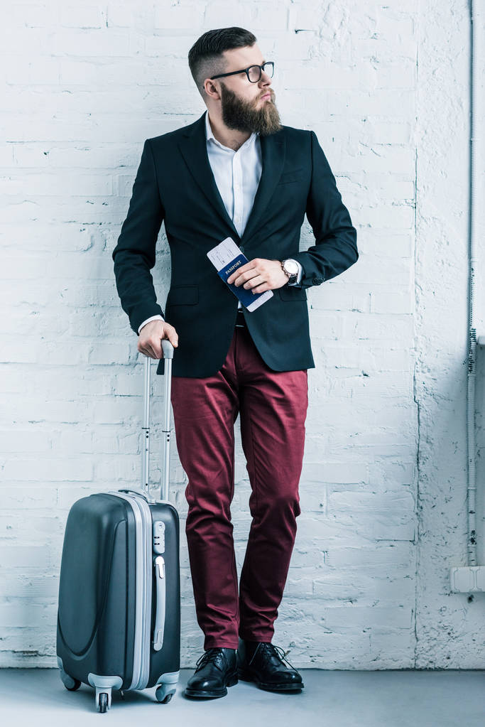 pensativo hombre de negocios con pasaporte, billete y equipaje mirando hacia otro lado
 - Foto, imagen