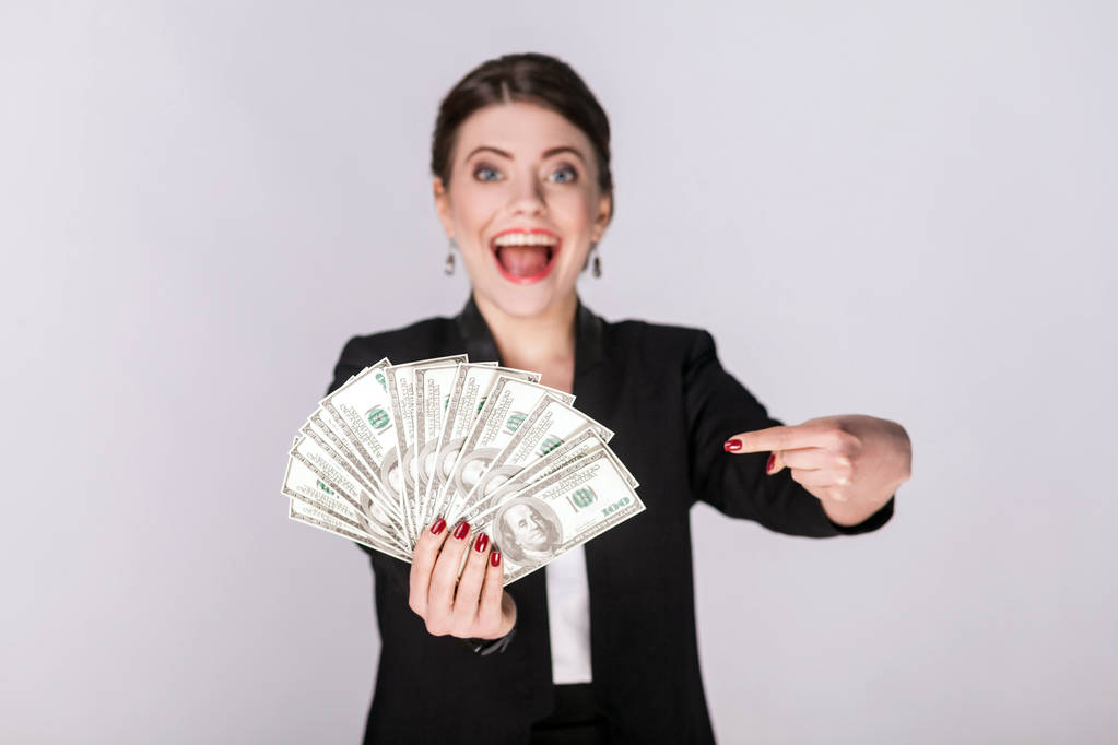 bien habillé femme pointant doigt à l'argent sur fond gris
  - Photo, image
