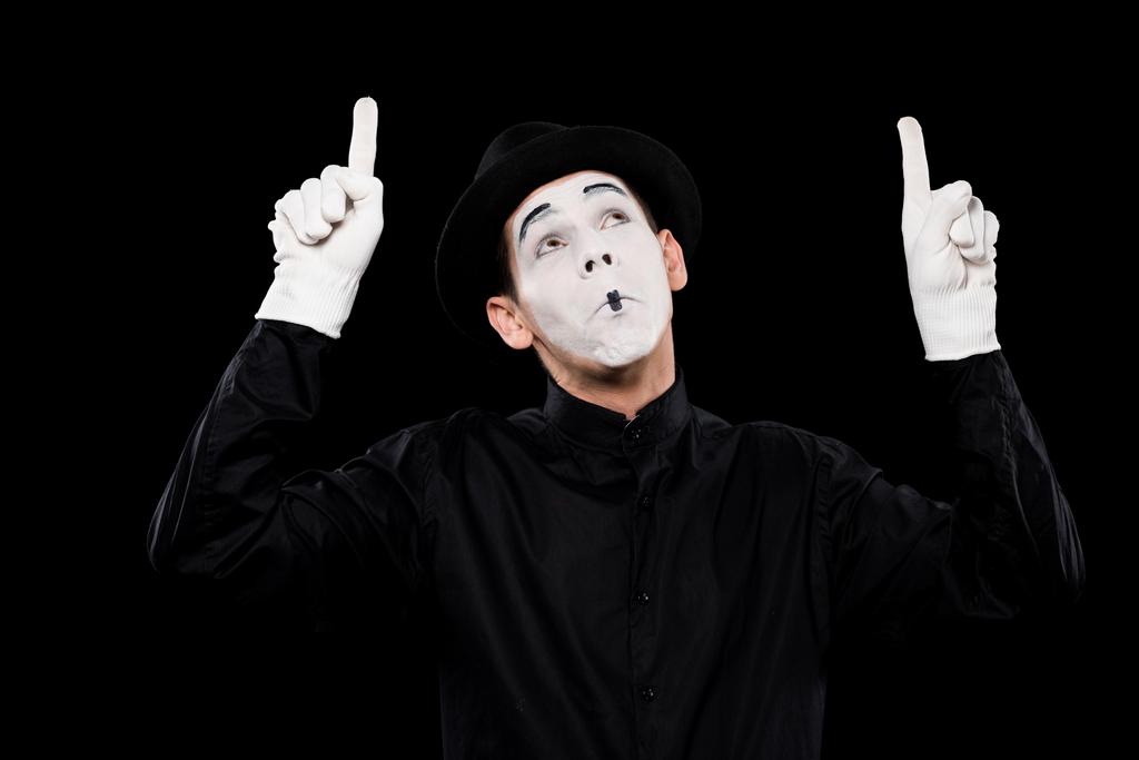 grimacing mime pointing on something isolated on black - Photo, Image