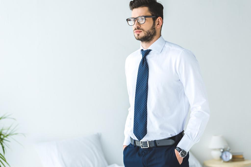 красивый бизнесмен в белой рубашке и галстуке, стоящий в спальне
 - Фото, изображение