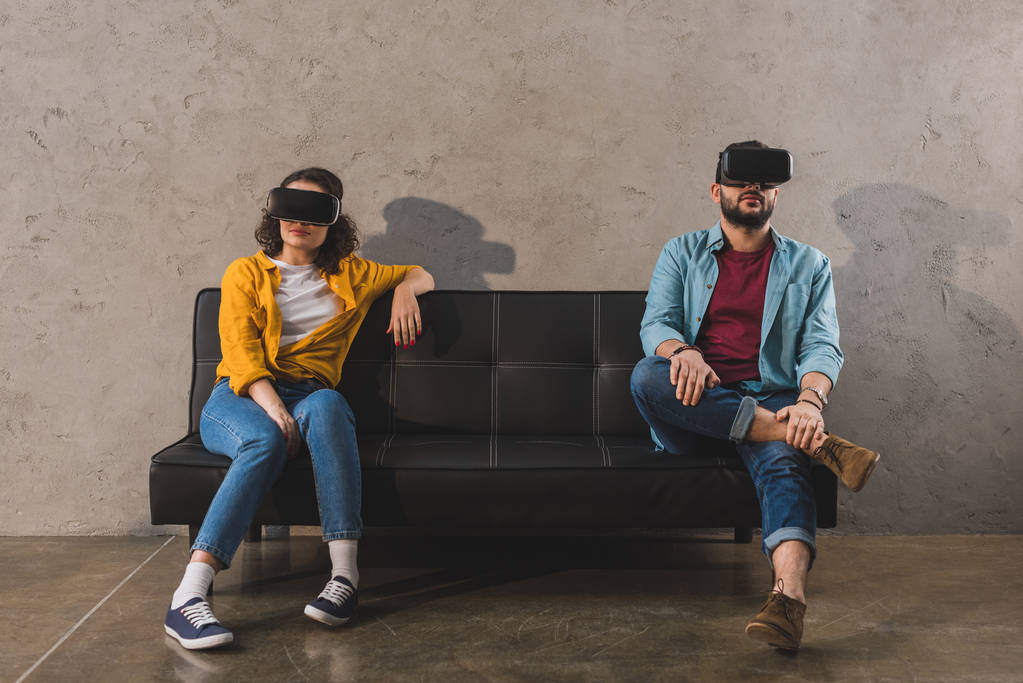 Vrouw en man zittend op de Bank en met behulp van virtual reality headset - Foto, afbeelding