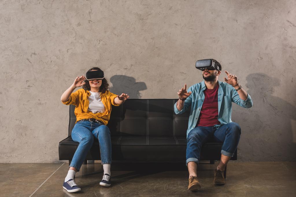 Couple having fun and using virtual reality headset on couch - Photo, Image