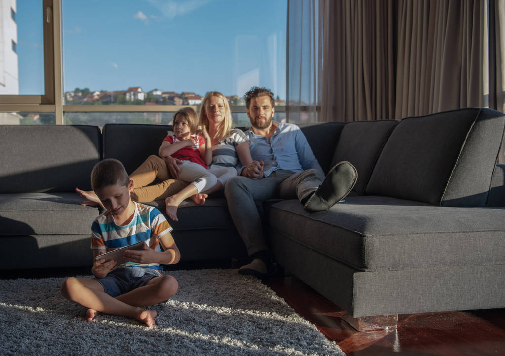 boldog pár időt töltenek a gyerekekkel használja tabletta számítógép kanapén otthon - Fotó, kép