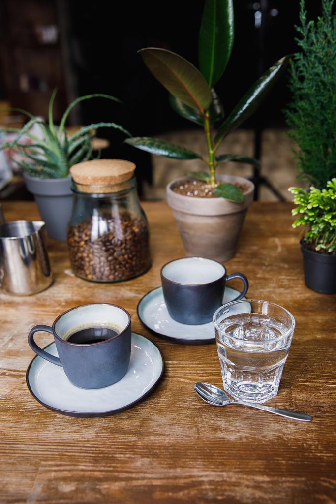 Kahvia ja vesilasia kahvilan pöydällä
 - Valokuva, kuva